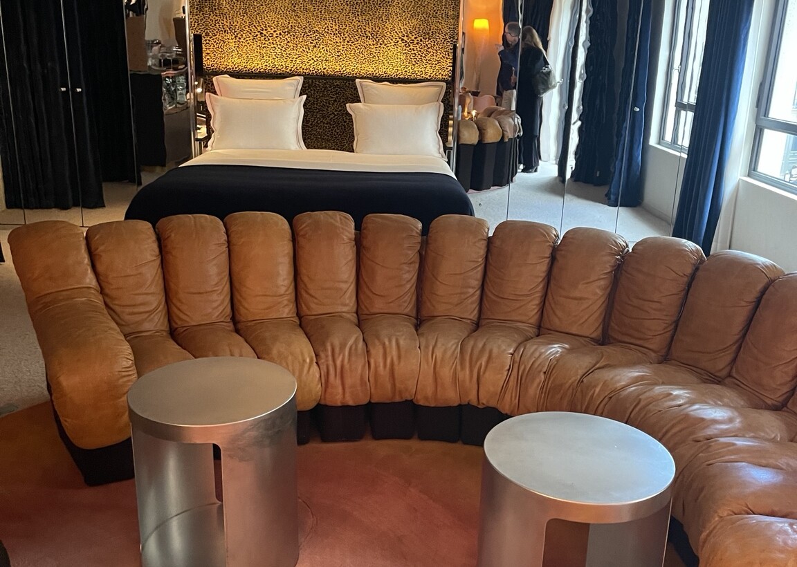 Leopard-print bedroom and curved leather seating in a Bus Palladium suite
